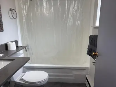 a white bathroom with a toilet and a shower at Advance Inn in Niagara Falls