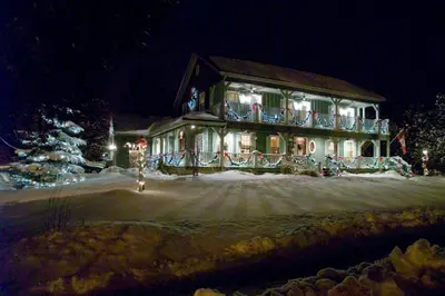 a house with christmas lights on it in the snow at WeatherPine Inn in Niagara on the Lake
