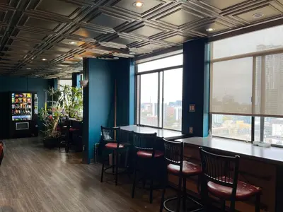 a bar in a restaurant with chairs and windows at Neill Wycik Hostel in Toronto