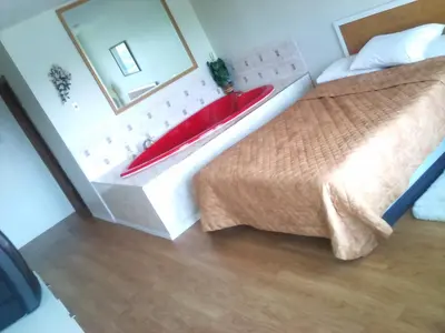a bedroom with a large bed with a red pillow at Rainbow Motor Inn - Fallsview in Niagara Falls