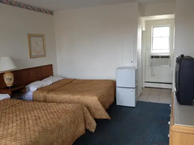a hotel room with two beds and a television at Rainbow Motor Inn - Fallsview in Niagara Falls