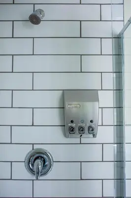 a shower in a white tiled bathroom at United College in Waterloo
