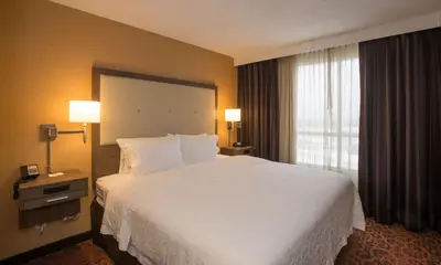 a hotel room with a large bed and a window at Hampton Inn Toronto-Mississauga West in Mississauga