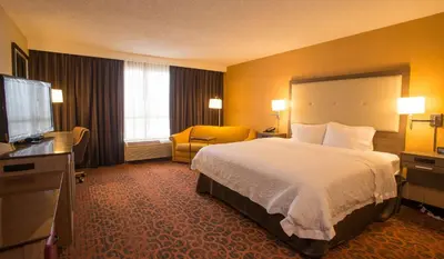 a hotel room with a bed and a flat screen tv at Hampton Inn Toronto-Mississauga West in Mississauga