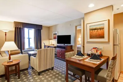 a hotel room with a desk and a living room at Homewood Suites by Hilton Toronto Mississauga in Mississauga