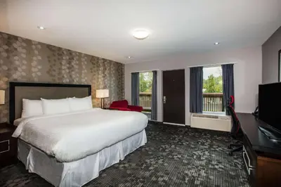 a hotel room with a bed and a television at Ramada by Wyndham Jackson's Point in Georgina