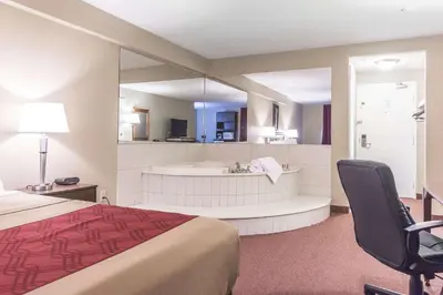 a hotel room with a bed and a bath tub at Econo Lodge in Orillia