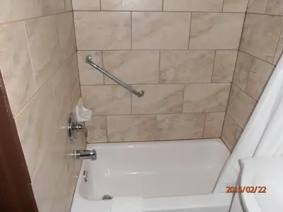 a bathroom with a shower with a tub and a toilet at Maples Motel in Orillia