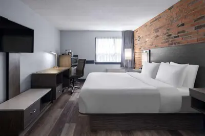 a hotel room with a large bed and a desk at Travelodge by Wyndham Barrie in Barrie