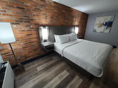 a bedroom with a bed and a brick wall at Travelodge by Wyndham Barrie in Barrie