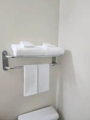 a bathroom with towels on a shelf above a toilet at Howard Johnson by Wyndham Lindsay in Lindsay