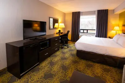 a hotel room with a bed and a flat screen tv at Comfort Hotel & Suites in Peterborough