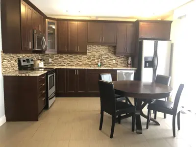 a kitchen with wooden cabinets and a table and chairs at Best Western Plus Barrie in Barrie