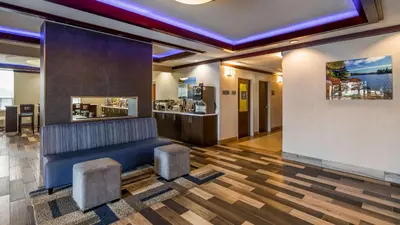 a lobby with a blue couch and two stools at Best Western Plus Barrie in Barrie