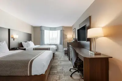 a hotel room with two beds and a desk with a computer at Best Western Milton in Milton