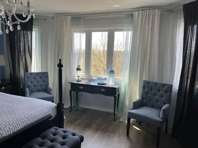 a bedroom with a bed and a desk and two chairs at Lulu's Bed & Breakfast in Niagara on the Lake