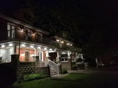 a house with lights on the side of it at night at Ambassador's Inn Next Door in Stratford