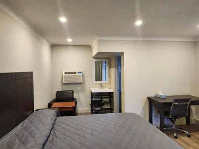 a bedroom with a bed and a desk and a desk at Fairway Inn & Suites in Kitchener