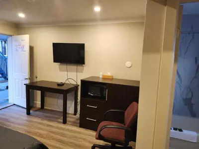 a room with a desk and a tv and a chair at Fairway Inn & Suites in Kitchener
