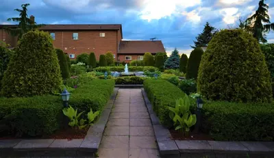 a garden in front of a building with a fountain at Newmarket Inn in Newmarket