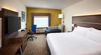 a hotel room with a bed and a desk with a television at Holiday Inn Express & Suites - Brantford by IHG in Brantford
