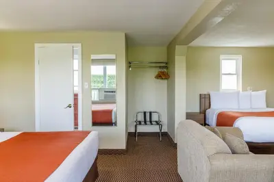 a hotel room with two beds and a chair at Motel 6 Campbellford, ON in Campbellford