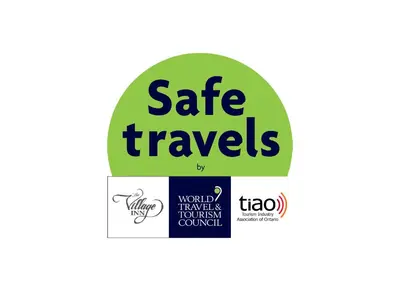 a green circle with the safe travels logo at The Village Inn of Lakefield in Lakefield