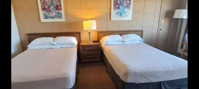 a hotel room with two beds and a table with a lamp at The Inn At Lock Seven in Thorold