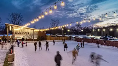 a group of people skating in the snow in front of a building at Pillar and Post Inn & Spa in Niagara on the Lake