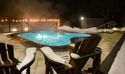 a swimming pool covered in snow with chairs and lights at Millcroft Inn & Spa in Alton