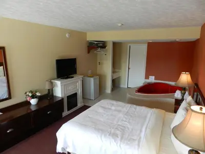 a bedroom with a bed and a tv and a couch at Kings Inn Near the Falls in Niagara Falls