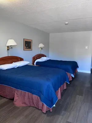 two beds in a hotel room with blue sheets at Knights Inn - Park Villa Motel, Midland in Midland