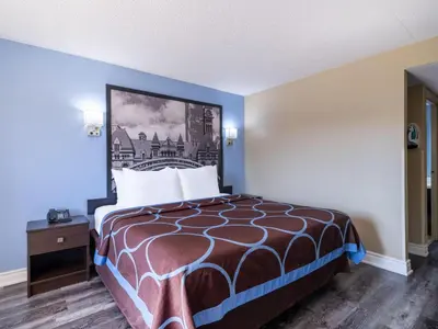 a hotel room with a bed and a painting on the wall at Super 8 by Wyndham Toronto East ON in Toronto