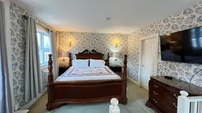 a bedroom with a bed and a television in it at Bedham Hall B&B in Niagara Falls