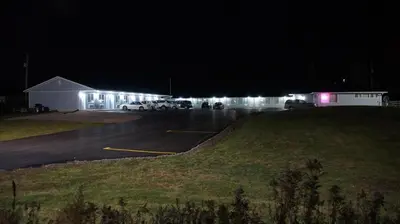 a parking lot at night with cars parked in it at Robyn's Motel in Peterborough