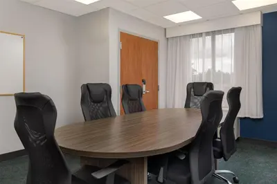 a conference room with a wooden table and chairs at Spark By Hilton Guelph in Guelph