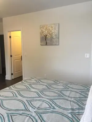 a bedroom with a bed and a painting on the wall at Comfortable private space in Pickering