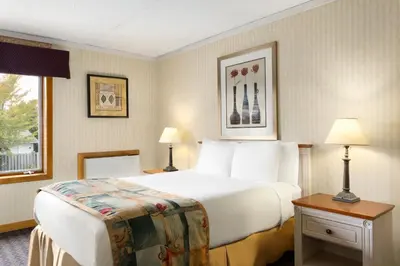 a hotel room with a large bed and two lamps at Travelodge by Wyndham Owen Sound ON in Owen Sound
