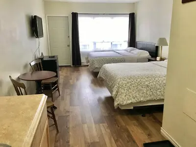 a hotel room with two beds and a table and a window at Lakeside Inn in Orillia