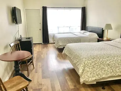 a hotel room with two beds and a table and a window at Lakeside Inn in Orillia