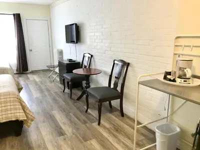 a room with two chairs and a table and a wall at Lakeside Inn in Orillia