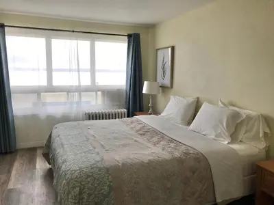 a bedroom with a large bed with a window at Lakeside Inn in Orillia