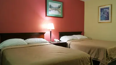 two beds in a hotel room with red walls at Blue Jay Motel in Peterborough