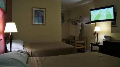 a hotel room with two beds and a flat screen tv at Blue Jay Motel in Peterborough