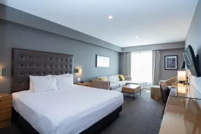 a hotel room with a bed and a couch at Sandman Hotel Hamilton in Hamilton