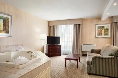 a hotel room with a tub and a chair at Days Inn by Wyndham Brantford in Brantford