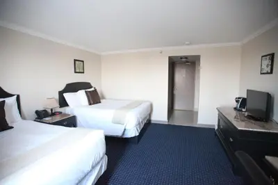 a hotel room with two beds and a flat screen tv at Montecassino Hotel & Event Centre in Toronto
