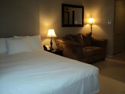 a bedroom with a bed and a couch and a chair at Montecassino Hotel & Event Centre in Toronto