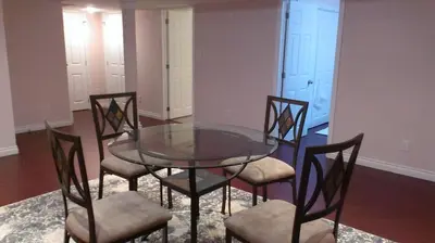 a glass table and four chairs in a room at HB Guest Home 5 in Waterloo