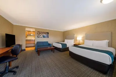 a hotel room with two beds and a desk at Best Western Voyageur Place Hotel in Newmarket